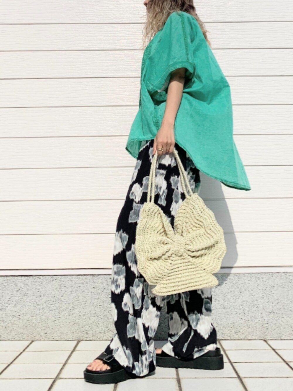 ホワイト系のトートバッグ、ブラック系のその他パンツ、ブラック系のサンダルを着用したレディースの春コーディネートの2枚目の写真