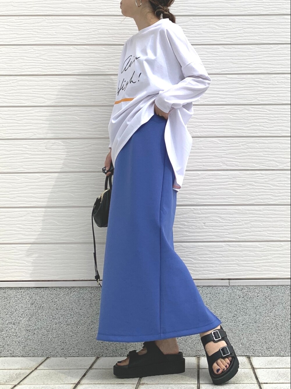 ブラック系のサンダル、ブラック系のショルダーバッグ、ブルー系のスカートを着用したレディースの春コーディネートの3枚目の写真