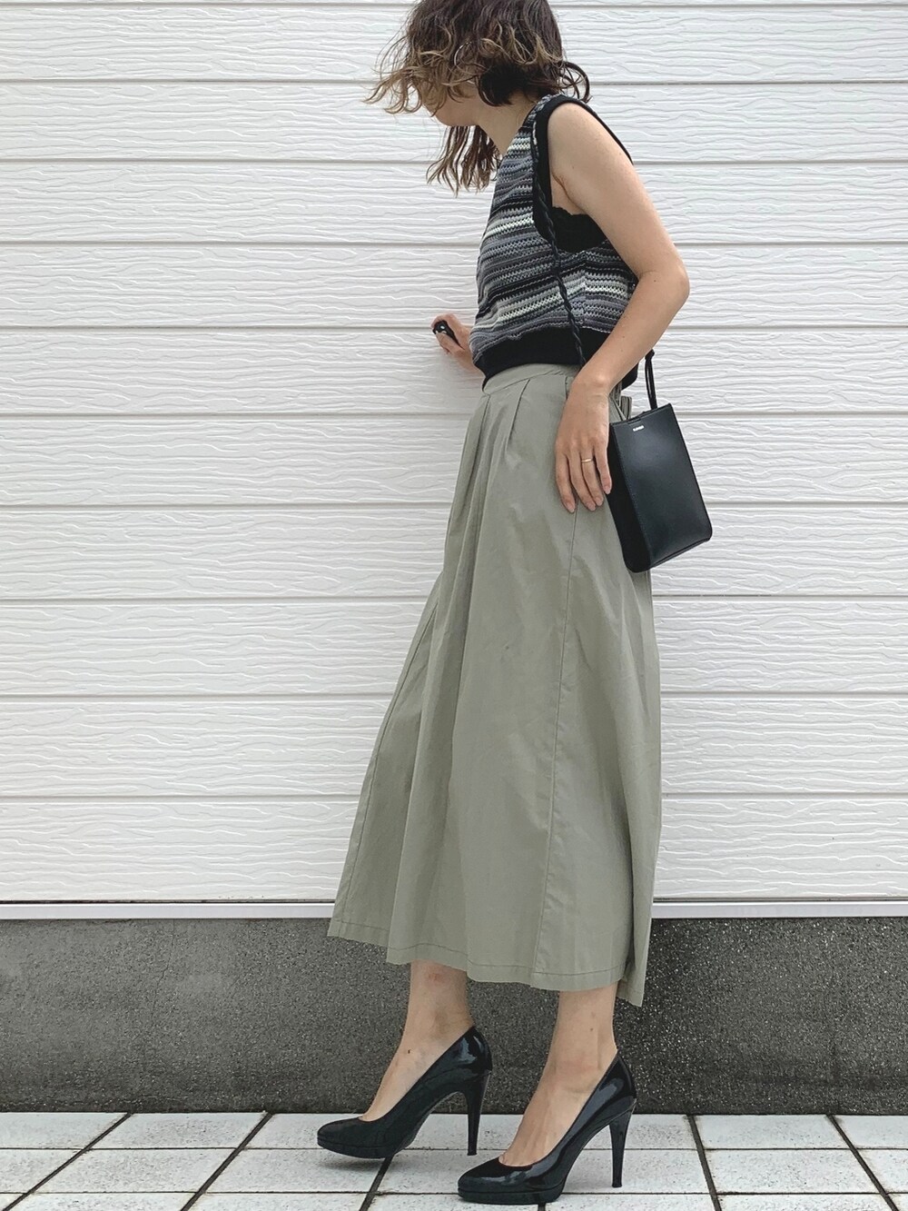 ブラック系のショルダーバッグ、ブラック系のベスト、グリーン系のその他パンツを着用したレディースの夏コーディネートの2枚目の写真