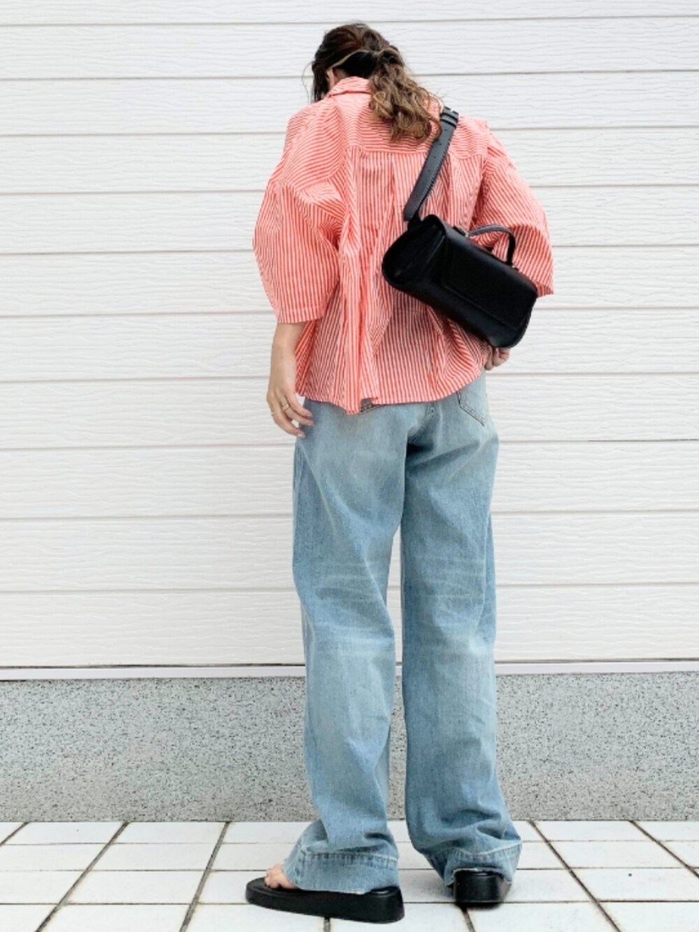 ブルー系のデニムパンツ、ベージュ系のタンクトップ、オレンジ系のシャツ/ブラウスを着用したレディースの夏コーディネートの2枚目の写真