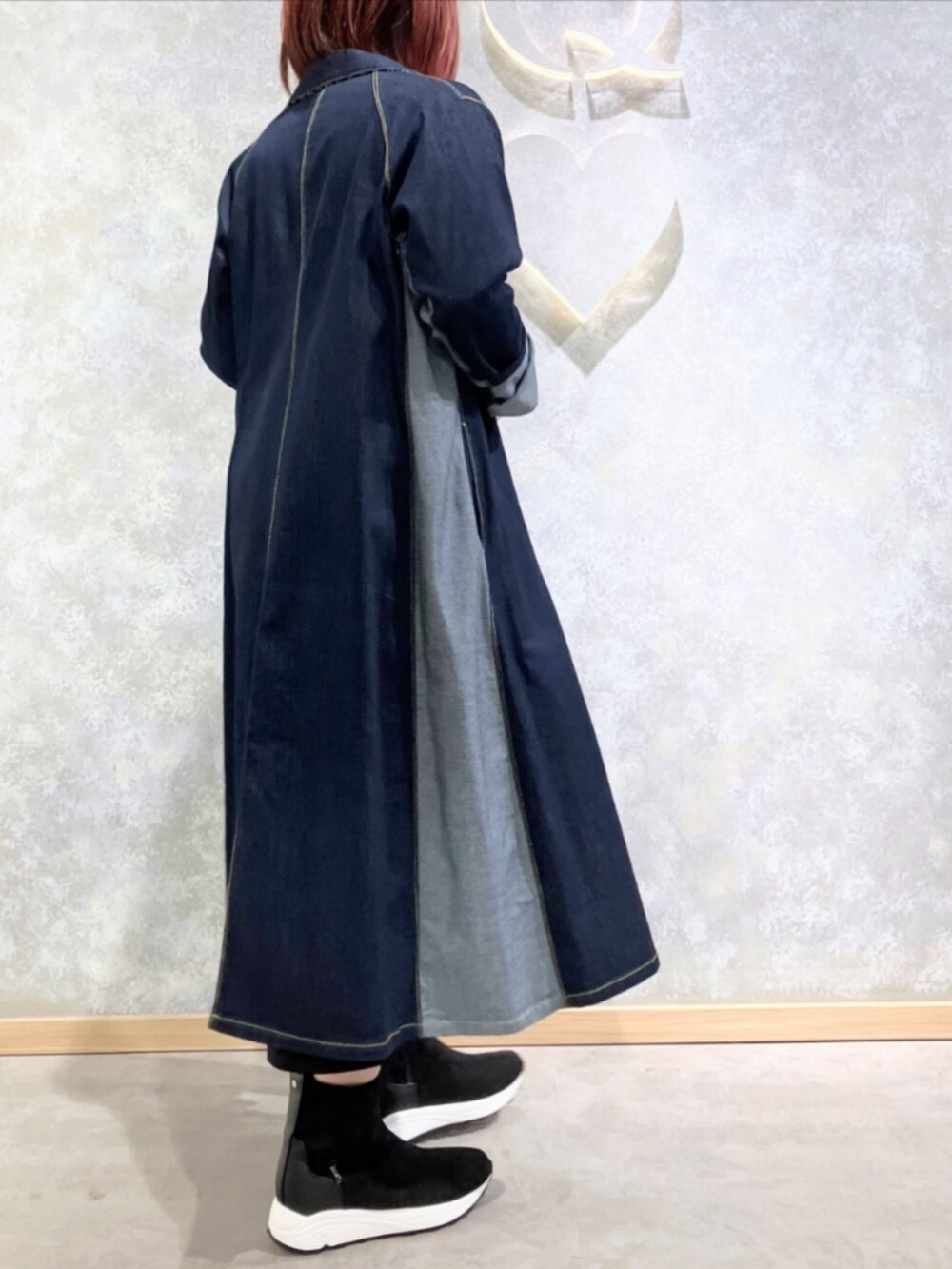 グレー系のブーツ、ブルー系のデニムジャケット、ブラック系のスカートを着用したレディースの秋コーディネートの3枚目の写真