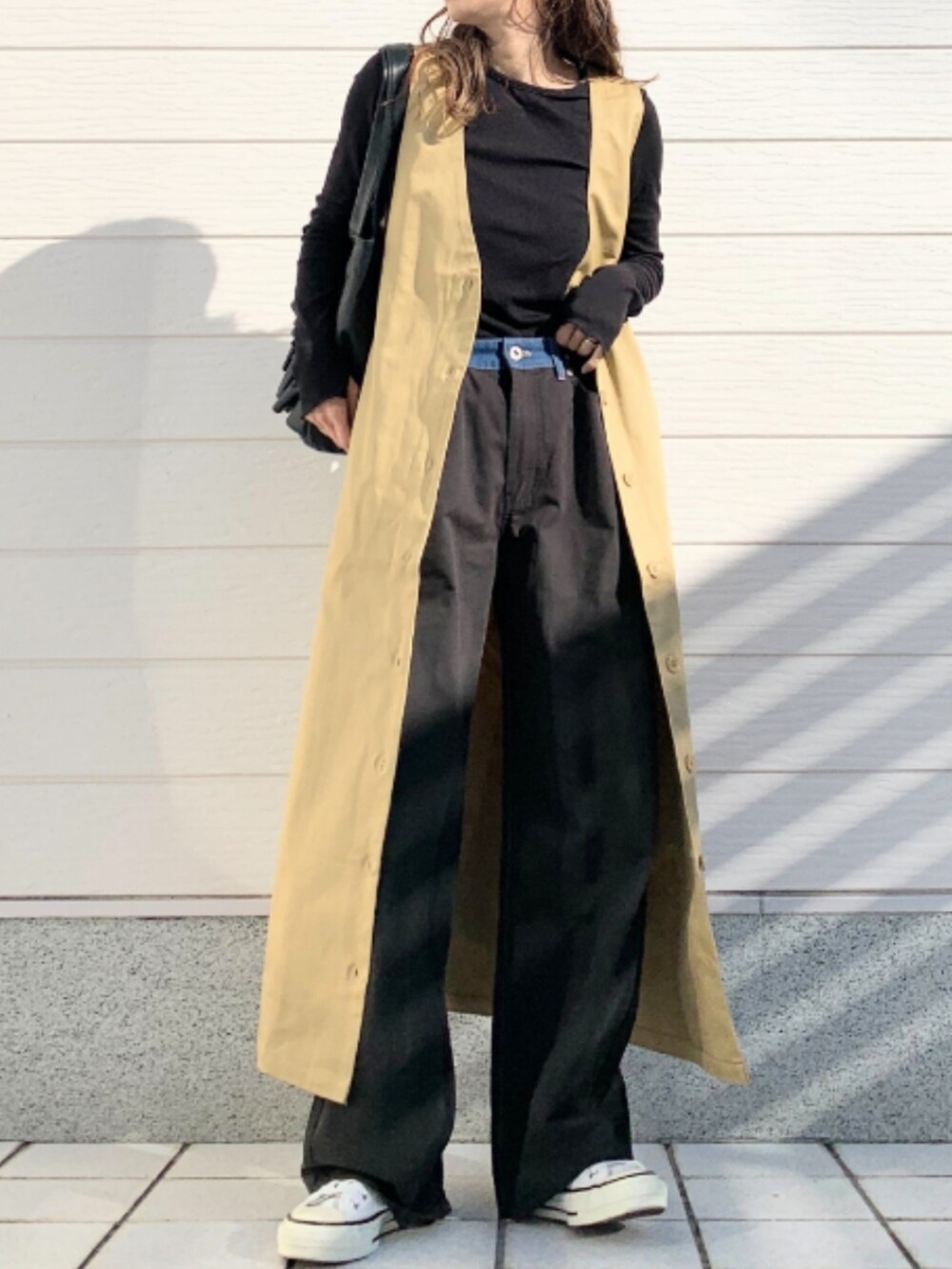 ベージュ系のジャンパースカート、ブラック系のトートバッグを着用したレディースの冬コーディネートの4枚目の写真