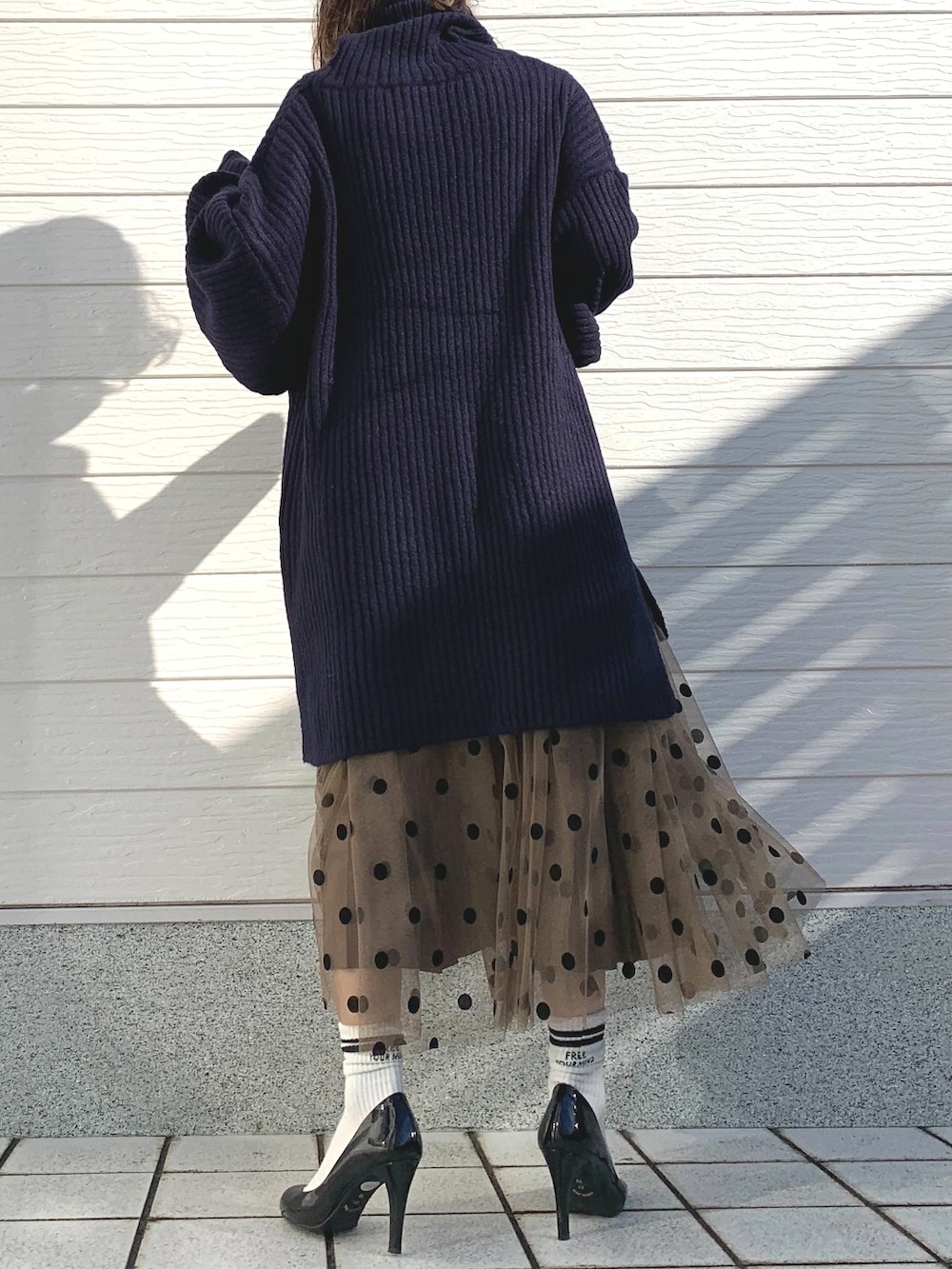 ブラウン系のスカート、ブルー系のニット/セーターを着用したレディースの冬コーディネートの3枚目の写真
