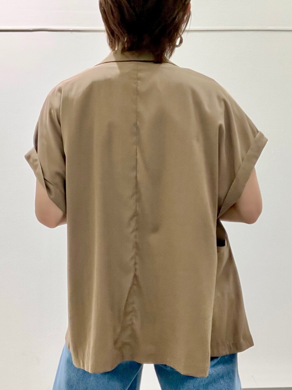 ブラック系のTシャツ/カットソー、グリーン系のテーラードジャケット、ブルー系のデニムパンツを着用したレディースの夏コーディネートの4枚目の写真