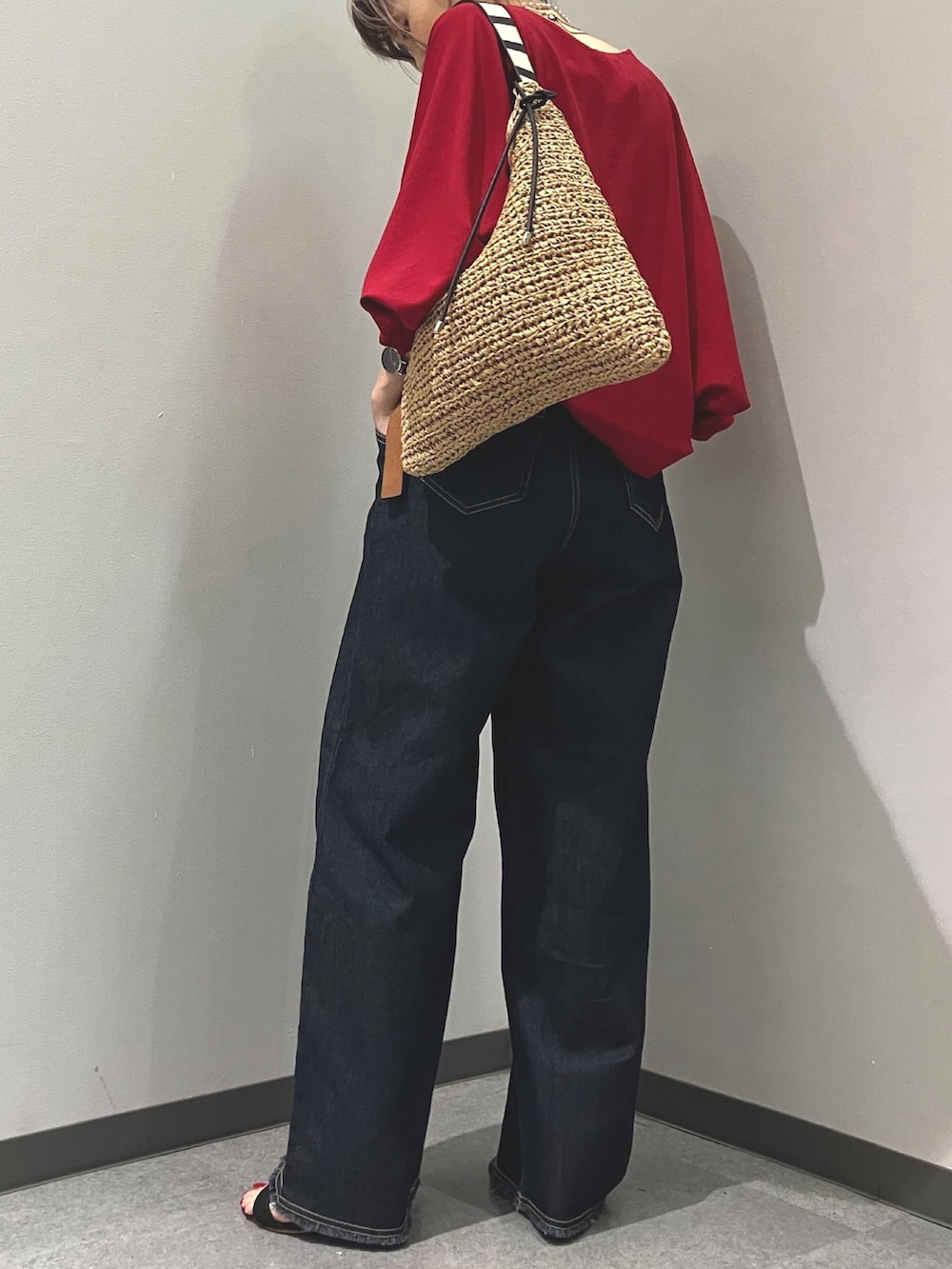 ブルー系のデニムパンツ、レッド系のシャツ/ブラウス、グリーン系のトートバッグを着用したレディースの夏コーディネートの2枚目の写真