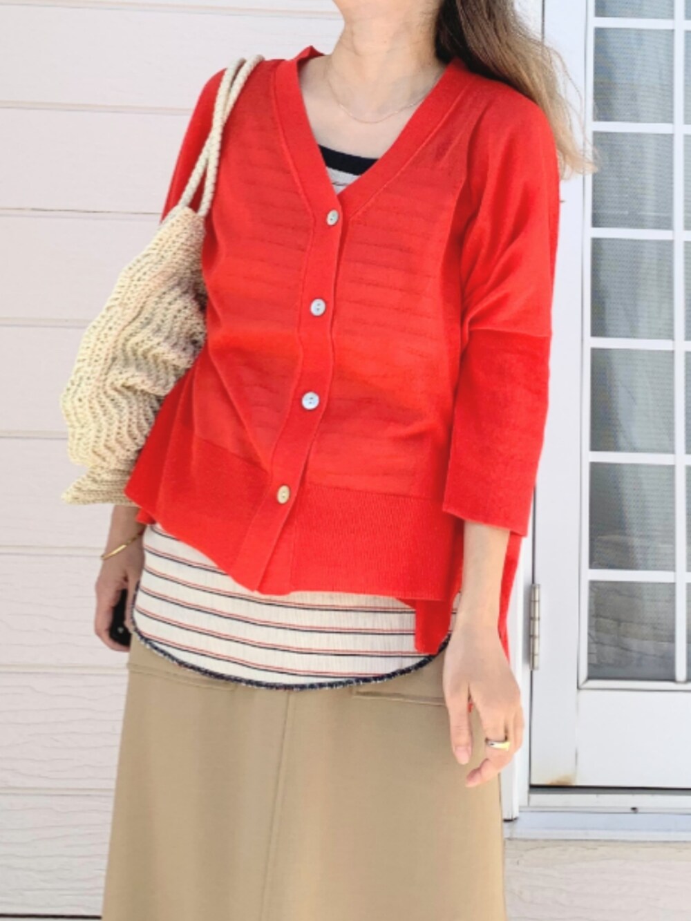 イエロー系のサンダル、オレンジ系のカーディガン/ボレロ、ホワイト系のトートバッグを着用したレディースの春コーディネートの4枚目の写真