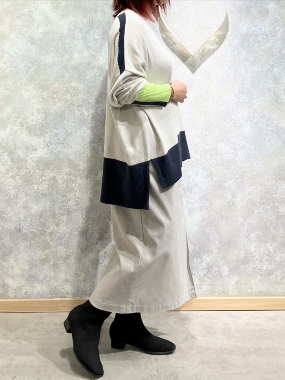 グレー系のスカート、ブラック系のブーツを着用したレディースの秋コーディネートの2枚目の写真