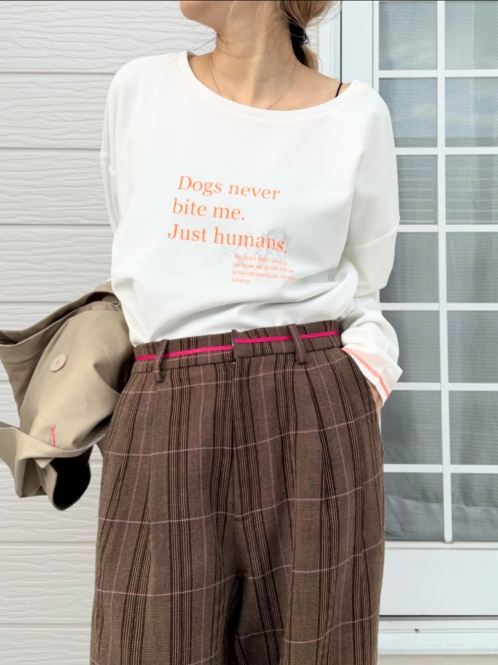 ホワイト系のTシャツ/カットソー、ベージュ系のトレンチコート、ブラウン系のスラックスを着用したレディースの冬コーディネートの5枚目の写真