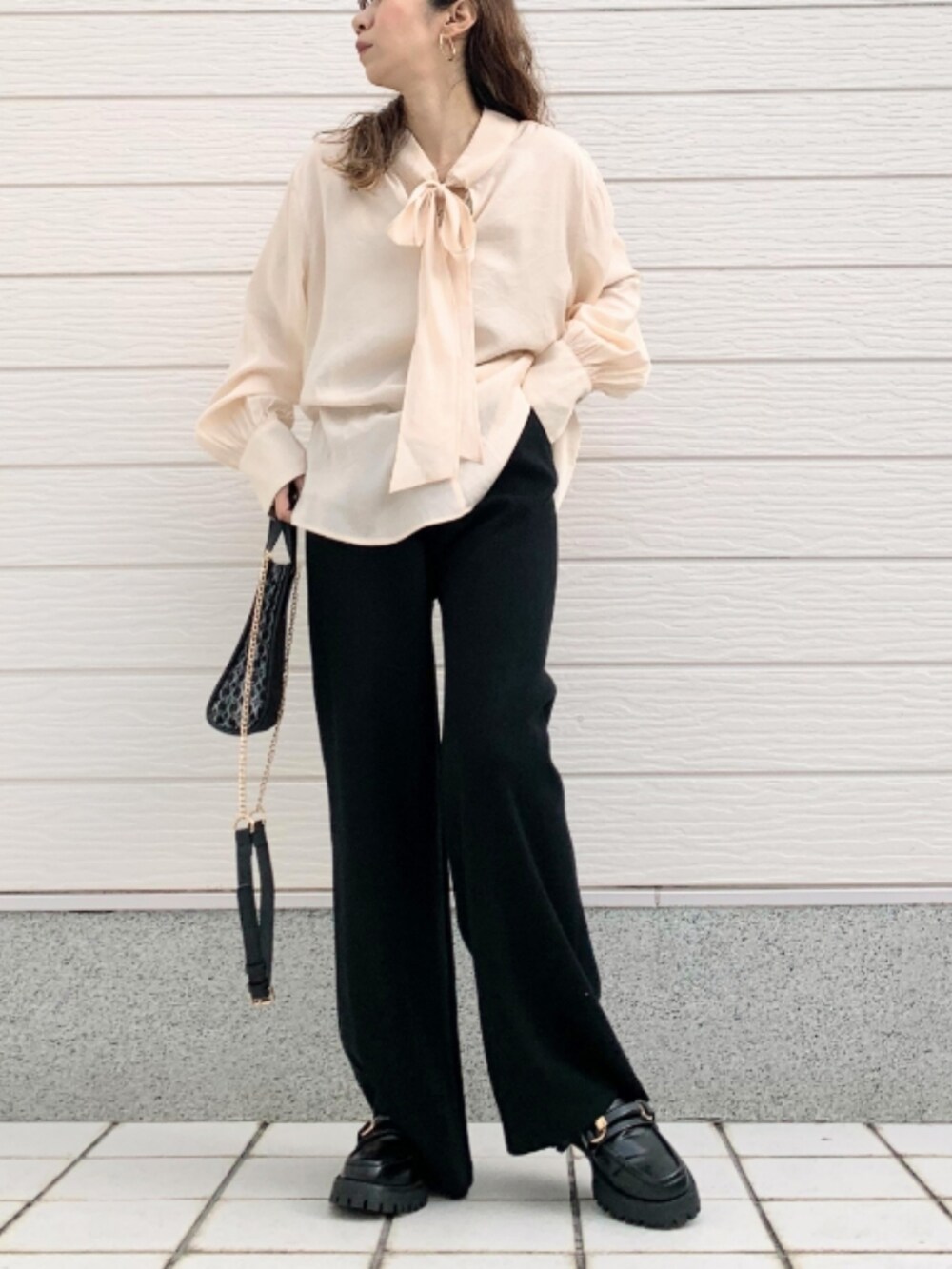 ブラック系のショルダーバッグ、ブラック系のローファー、ホワイト系のシャツ/ブラウスを着用したレディースの冬コーディネートの2枚目の写真