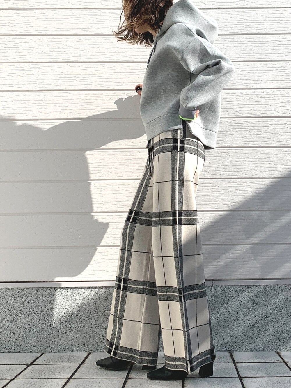 ブラック系のショルダーバッグ、グレー系のパーカー、ホワイト系のその他パンツを着用したレディースの冬コーディネートの2枚目の写真