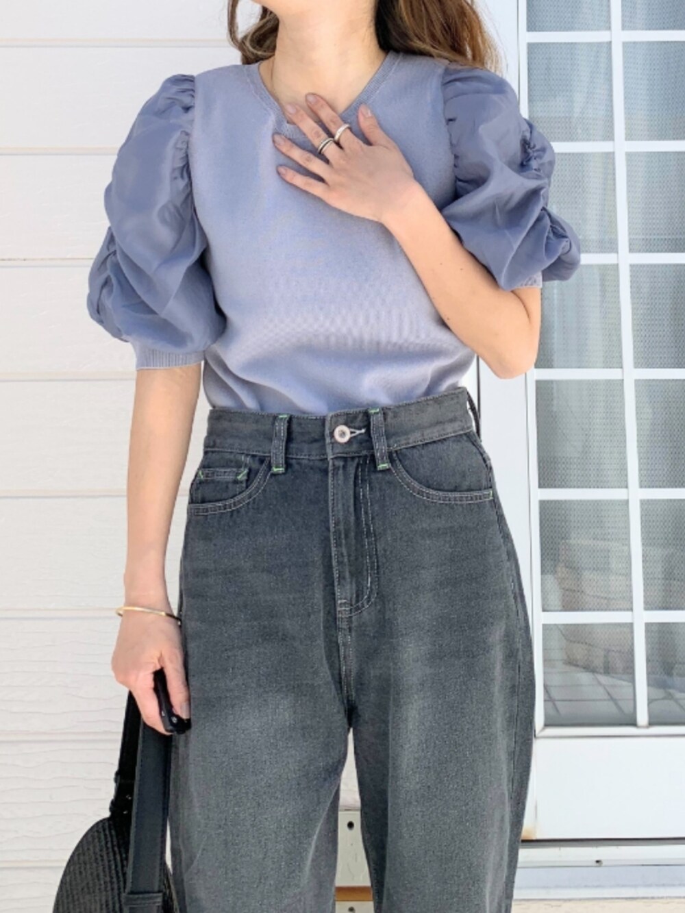 グレー系のデニムパンツ、ブラック系のショルダーバッグ、ブルー系のニット/セーターを着用したレディースの春コーディネートの3枚目の写真