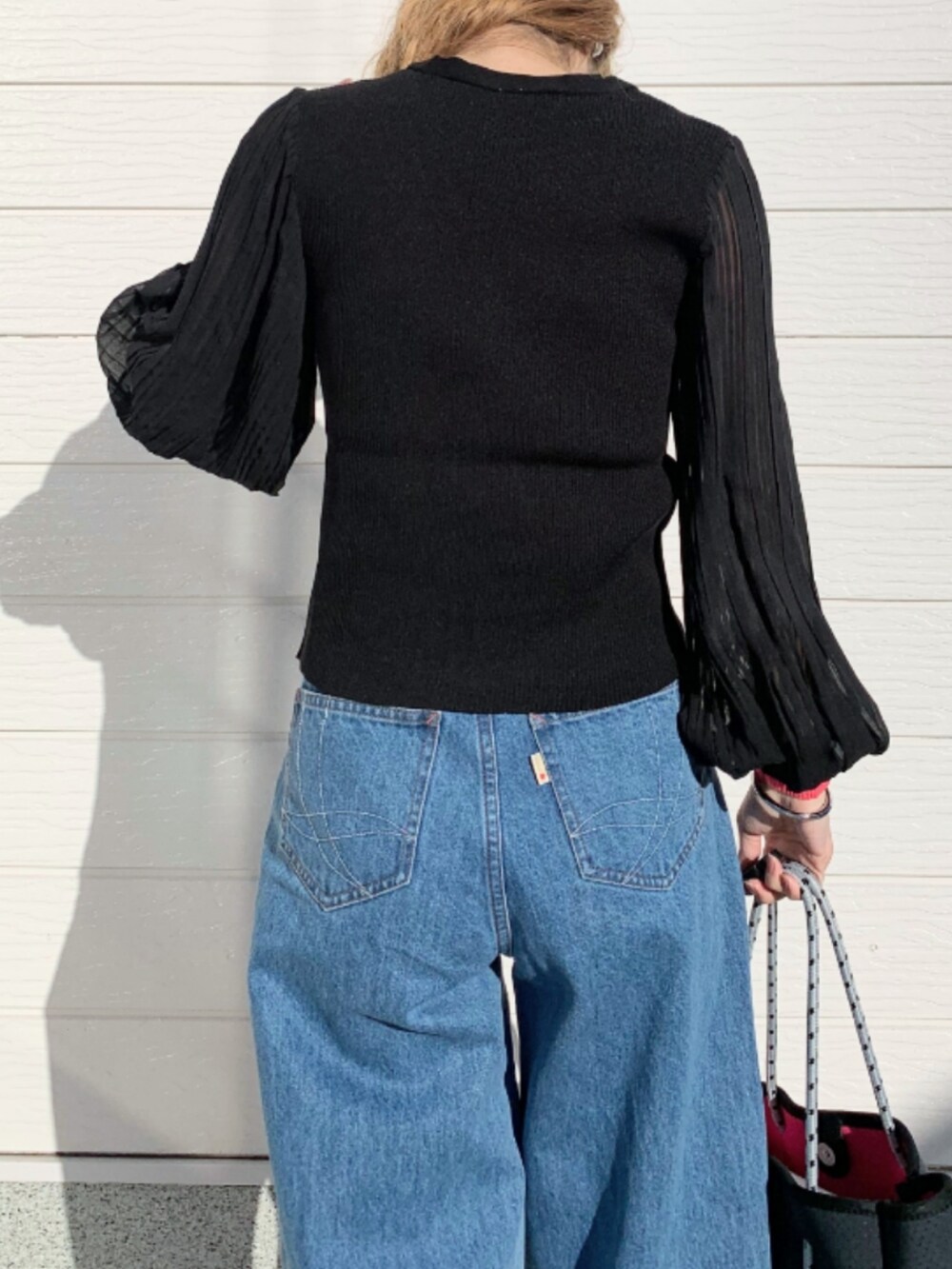 ブルー系のデニムパンツ、ホワイト系のスニーカー、ブルー系のトートバッグを着用したレディースの冬コーディネートの5枚目の写真