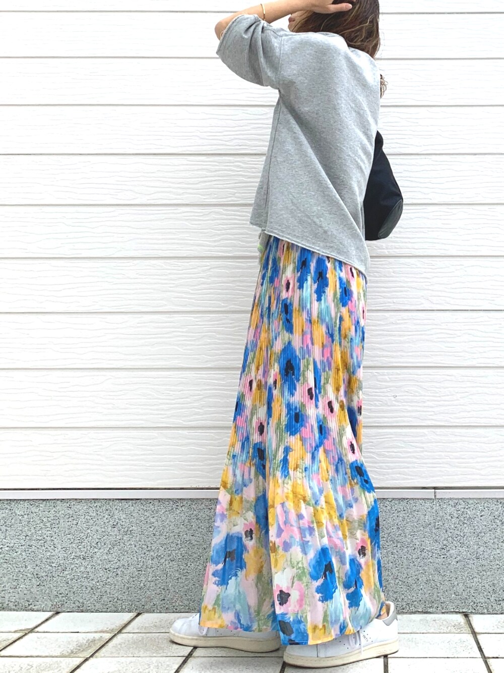 ホワイト系のスニーカー、ブラック系のショルダーバッグ、ブルー系のスカートを着用したレディースの春コーディネートの3枚目の写真