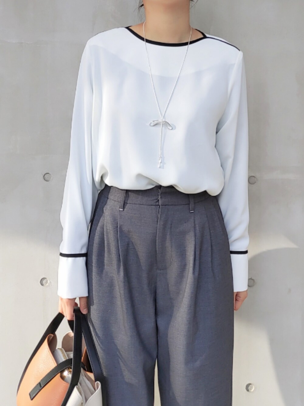 グレー系のスラックス、グレー系のノーカラージャケット、ホワイト系のシャツ/ブラウスを着用したレディースの冬コーディネートの4枚目の写真