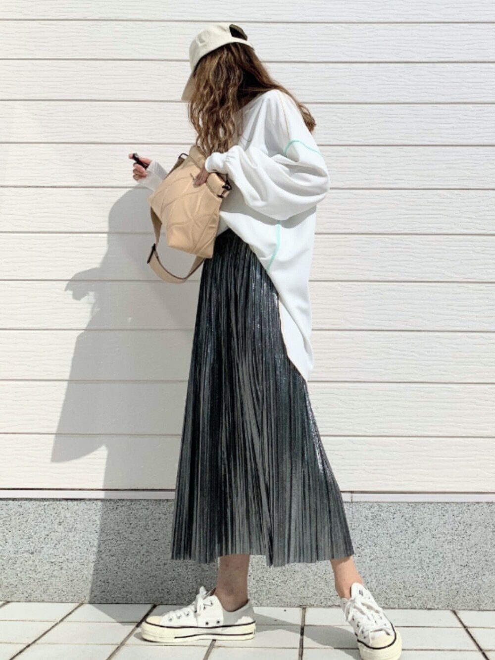 ホワイト系のTシャツ/カットソー、ホワイト系のスニーカー、シルバー系のスカートを着用したレディースの春コーディネートの3枚目の写真