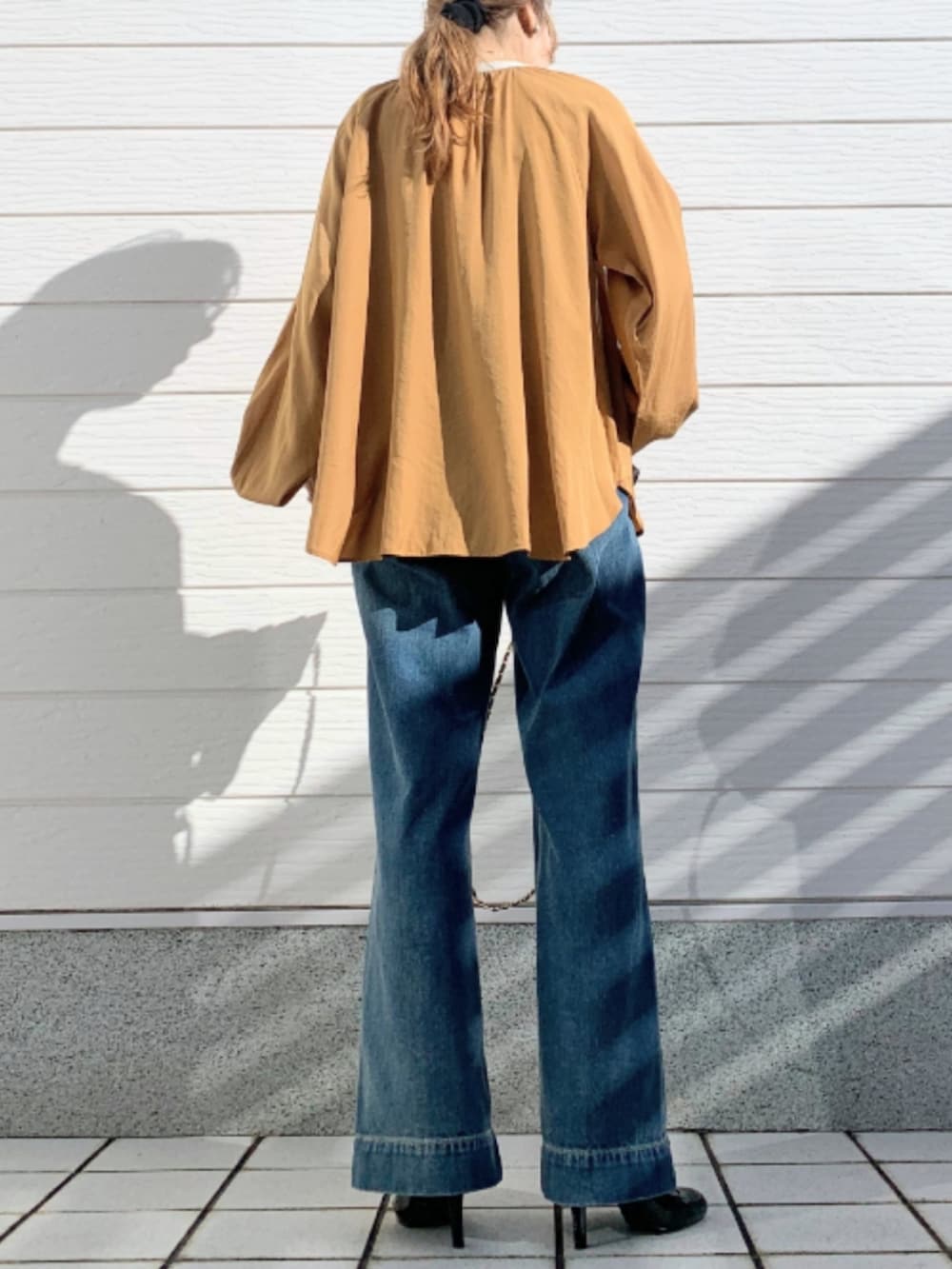 ブルー系のデニムパンツ、ブラウン系のシャツ/ブラウスを着用したレディースの冬コーディネートの3枚目の写真