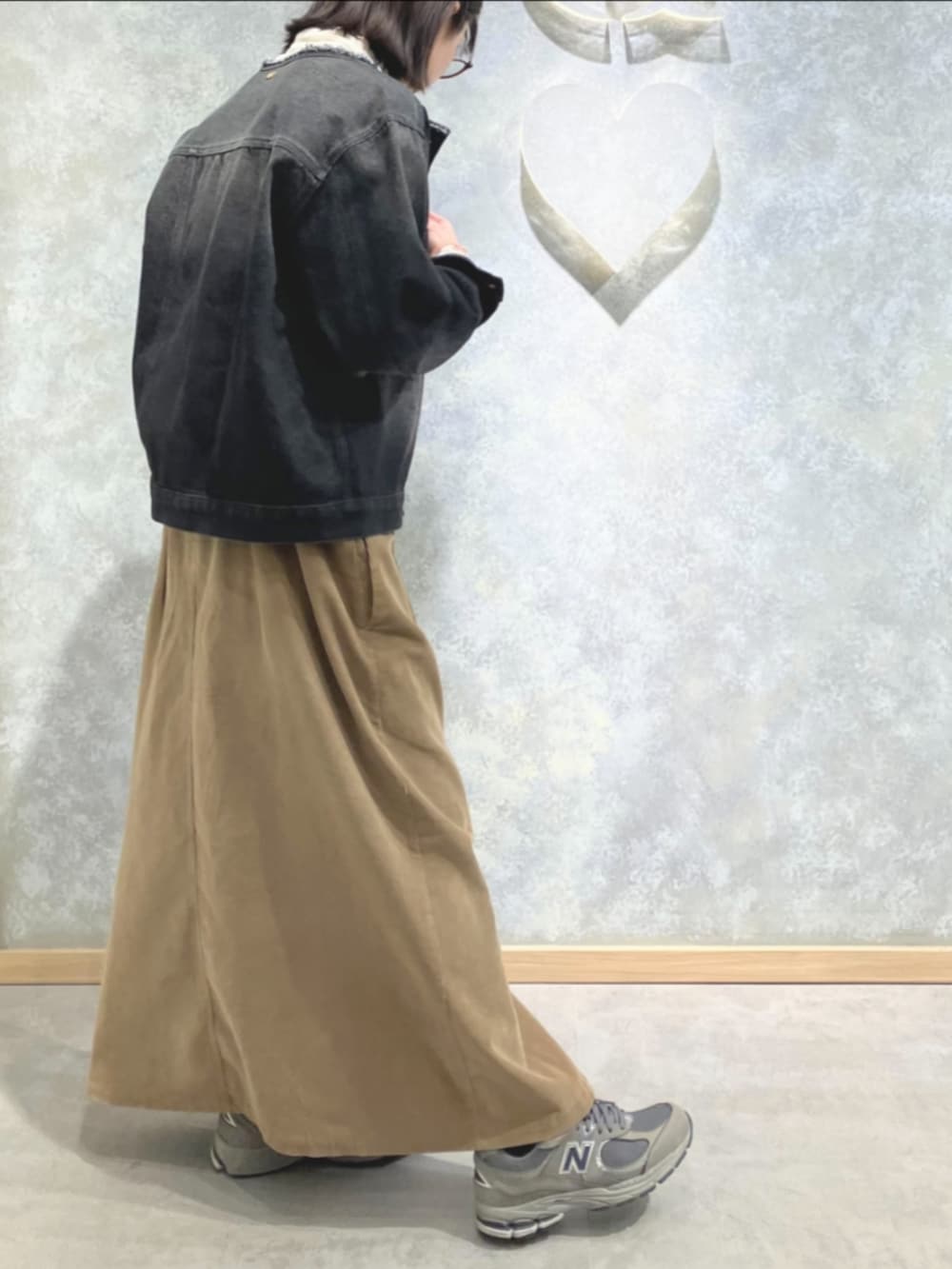 ブラック系のデニムジャケット、ベージュ系のワンピース、ホワイト系のTシャツ/カットソーを着用したレディースの冬コーディネートの3枚目の写真