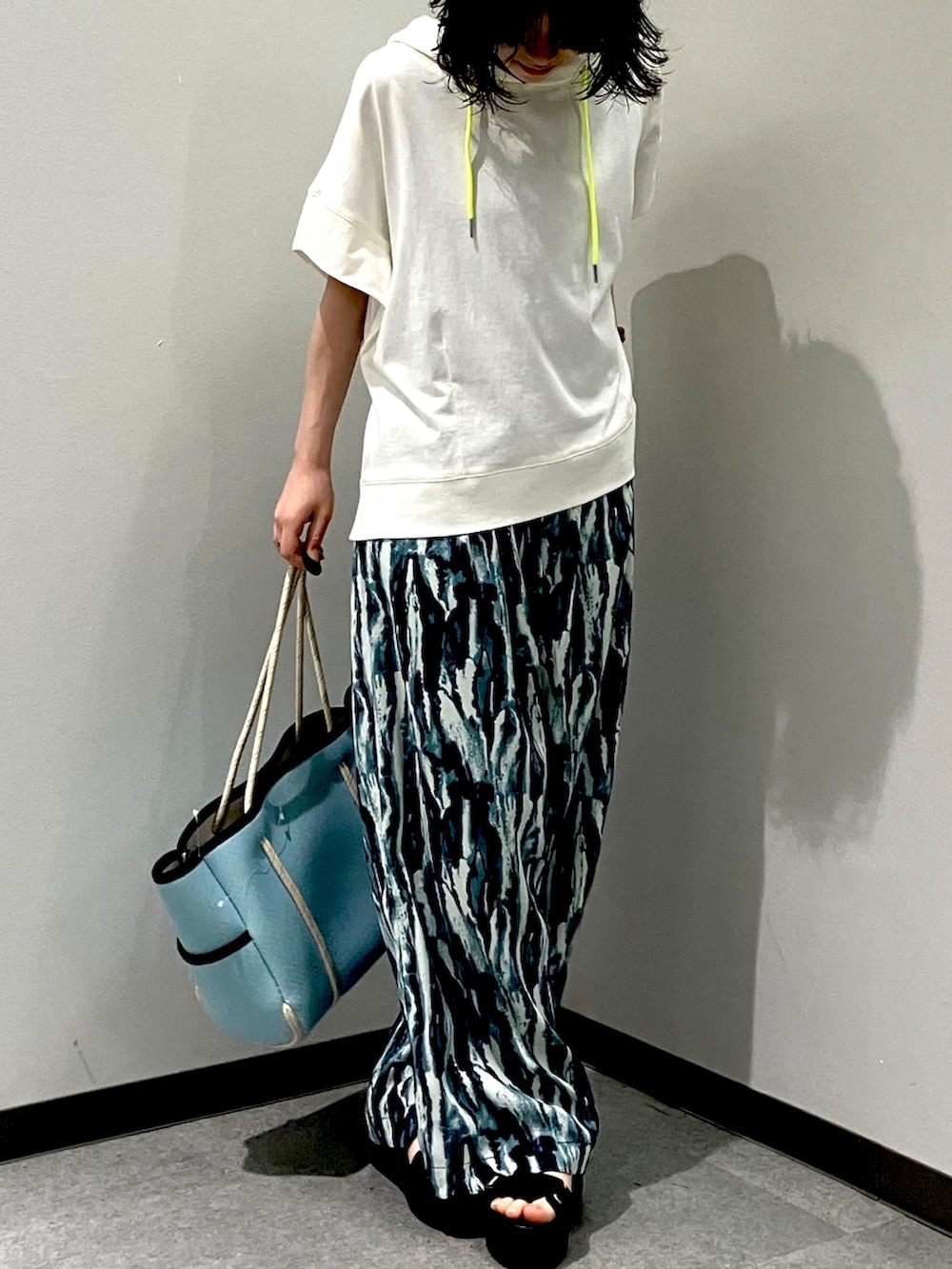 ブルー系のその他パンツ、ホワイト系のパーカー、ブルー系のトートバッグを着用したレディースの夏コーディネートの2枚目の写真