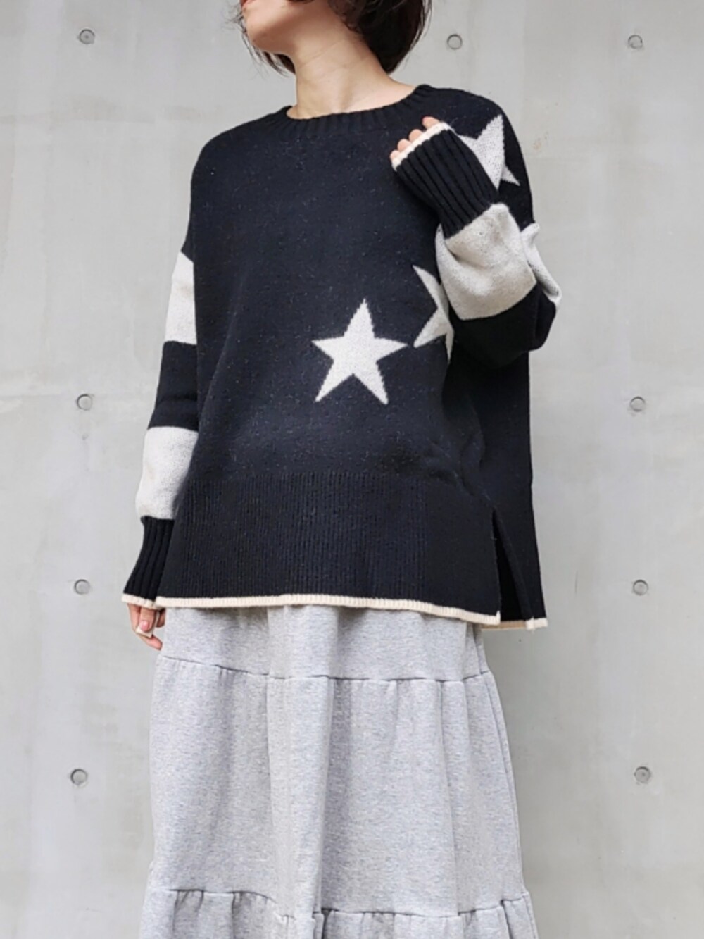 グレー系のスカート、ブラック系のニット/セーターを着用したレディースの秋コーディネートの4枚目の写真