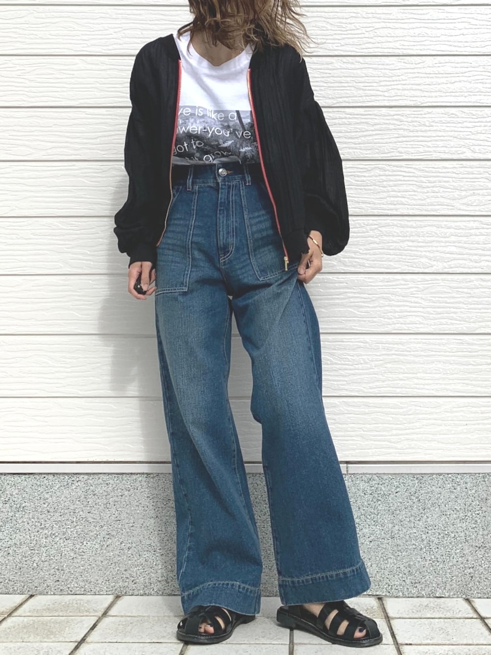 ブラック系のサンダル、ブルー系のデニムパンツ、ホワイト系のTシャツ/カットソーを着用したレディースの春コーディネートの2枚目の写真