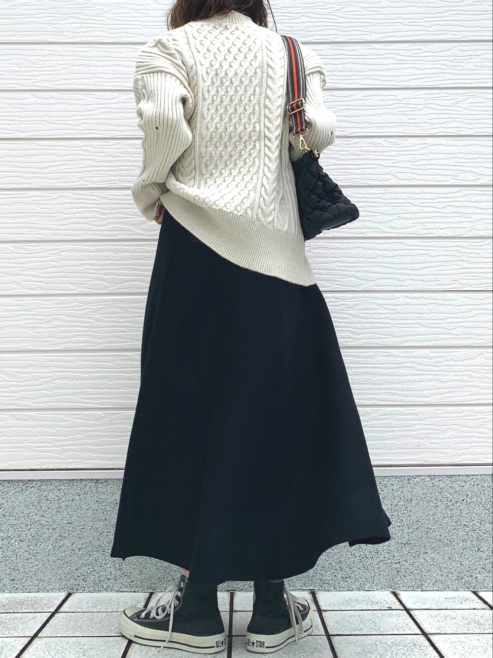 ブラック系のショルダーバッグ、ブラック系のスニーカー、ホワイト系のニット/セーターを着用したレディースの冬コーディネートの4枚目の写真