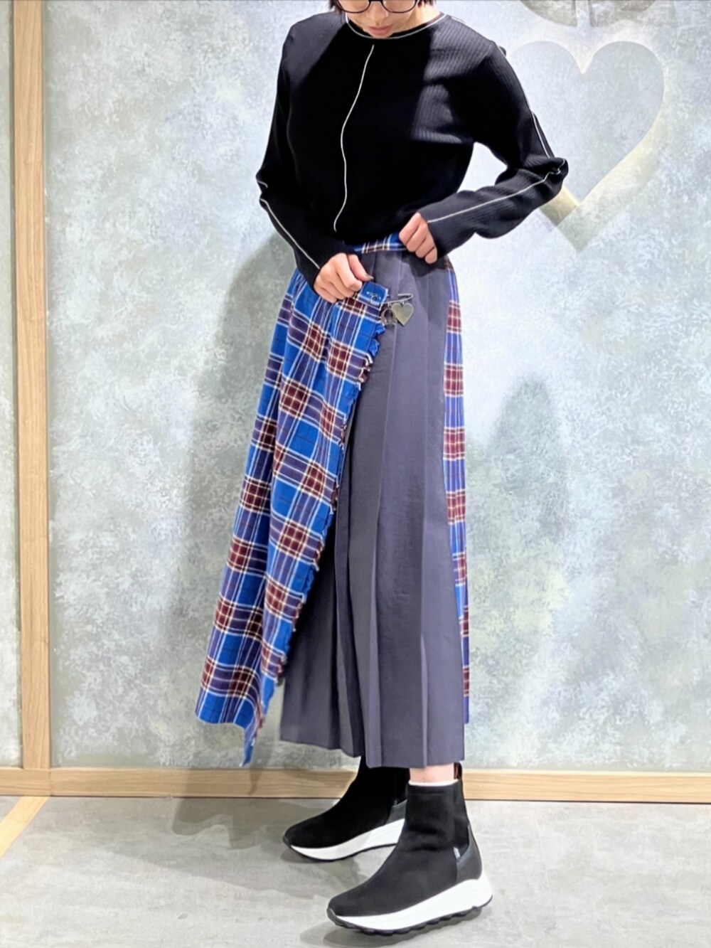 ブラック系のブーツ、グレー系のクラッチバッグ、ブラック系のニット/セーターを着用したレディースの秋コーディネートの2枚目の写真