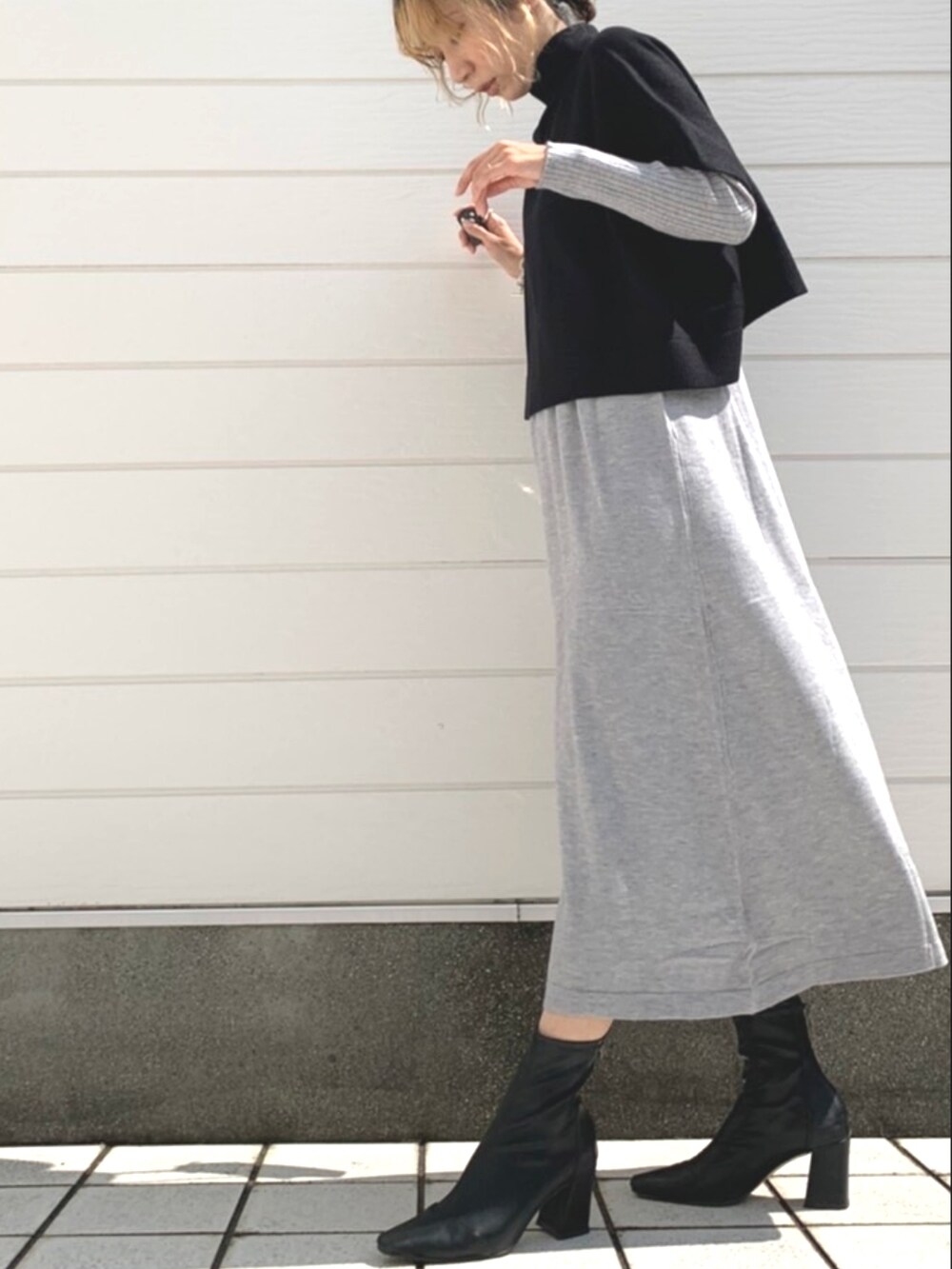 シルバー系のショルダーバッグ、グレー系のワンピースを着用したレディースの秋コーディネートの2枚目の写真