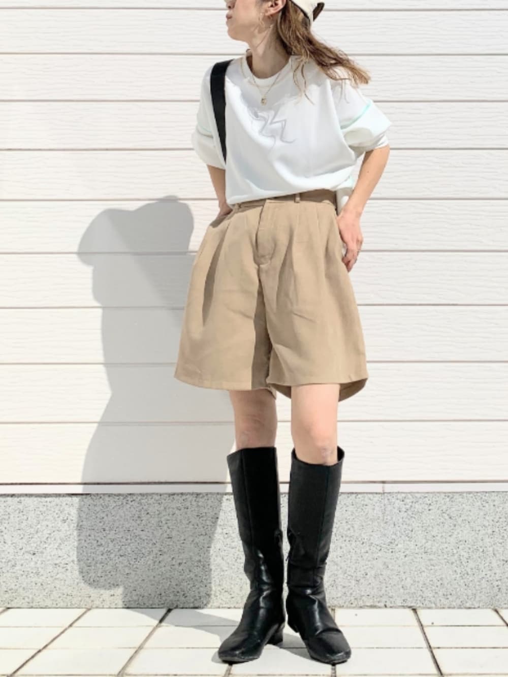 ブラック系のブーツ、ホワイト系のTシャツ/カットソー、ベージュ系のその他パンツを着用したレディースの春コーディネートの2枚目の写真