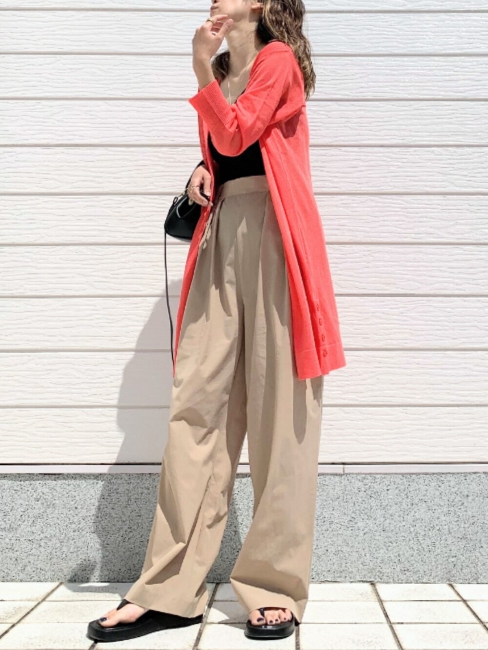 ベージュ系のその他パンツ、ブラック系のショルダーバッグ、オレンジ系のカーディガン/ボレロを着用したレディースの春コーディネートの2枚目の写真