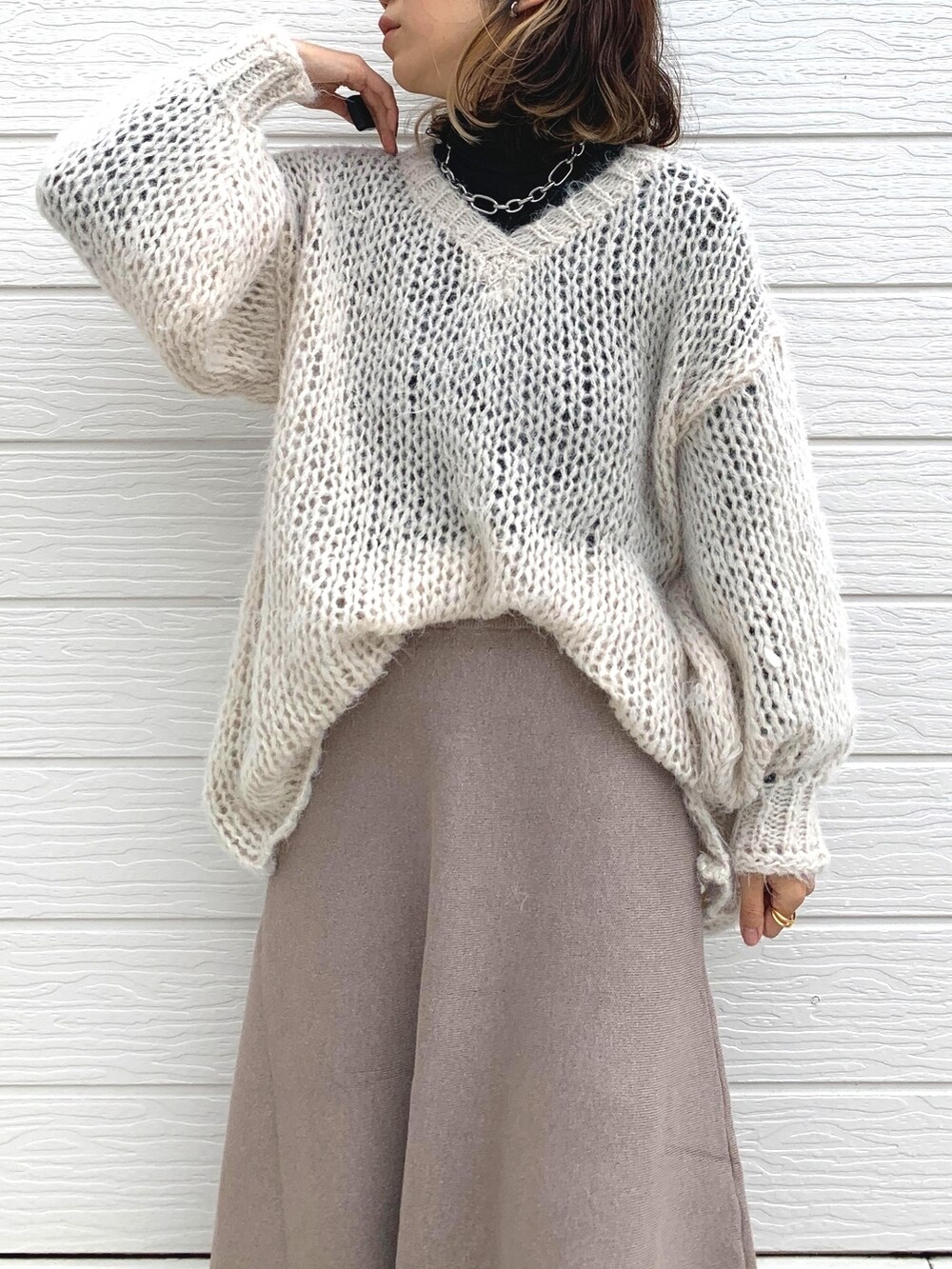 ホワイト系のニット/セーター、ブラック系のTシャツ/カットソー、ブラック系のスニーカーを着用したレディースの冬コーディネートの4枚目の写真