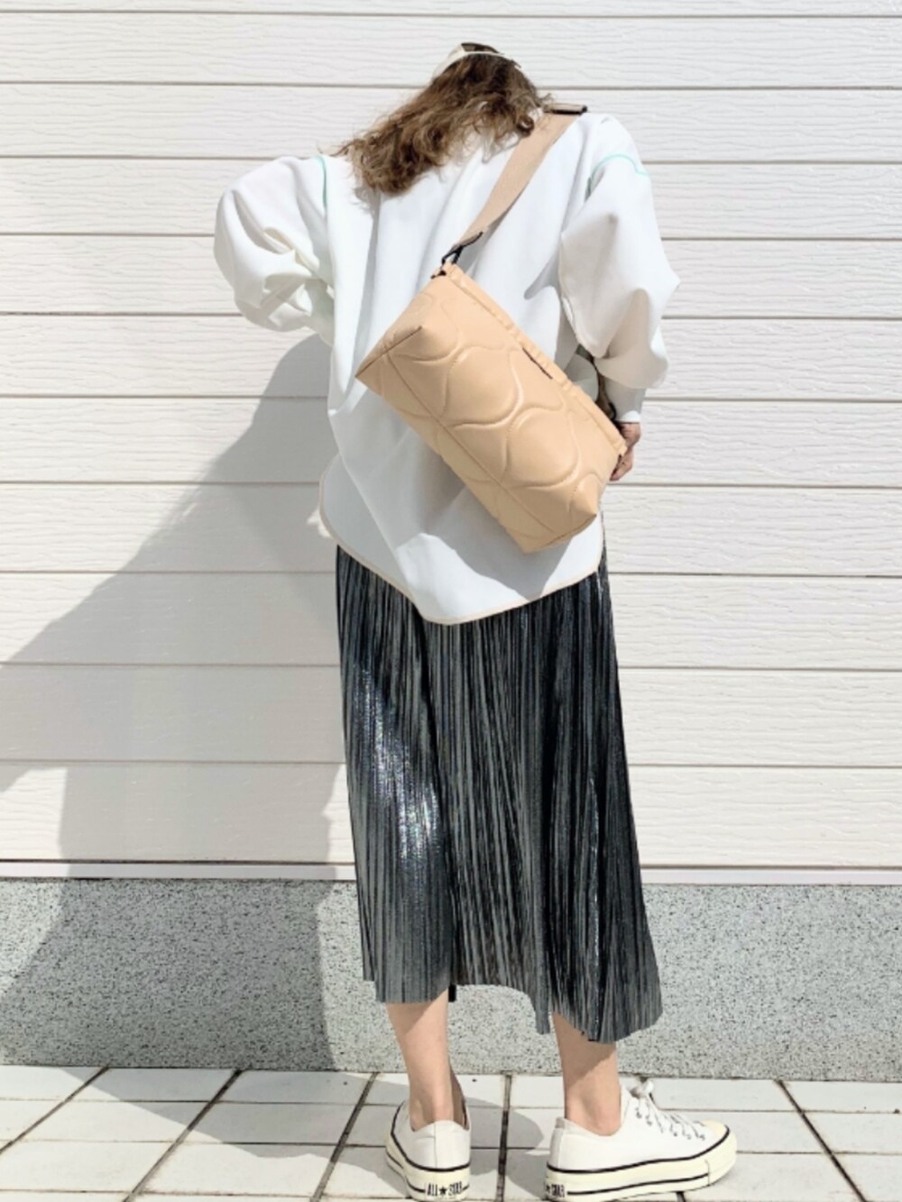 ホワイト系のTシャツ/カットソー、ホワイト系のスニーカー、シルバー系のスカートを着用したレディースの春コーディネートの4枚目の写真