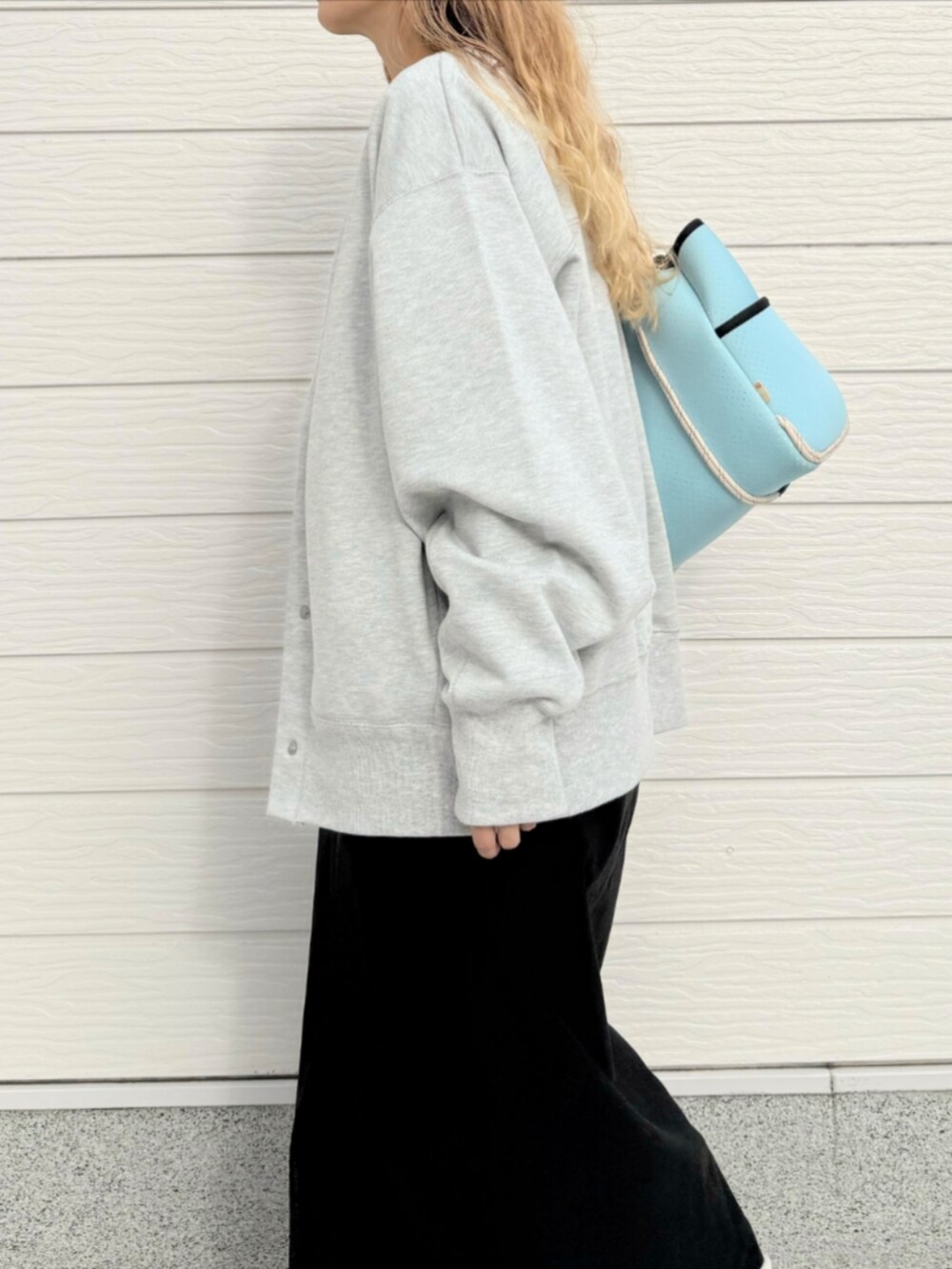 シルバー系のスニーカー、ブラック系のスカート、ブルー系のトートバッグを着用したレディースの秋コーディネートの4枚目の写真