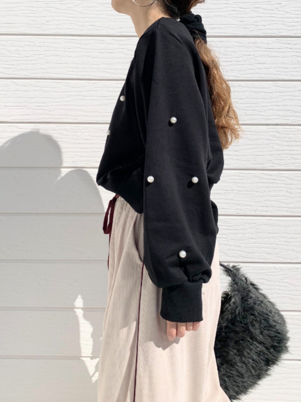 グレー系のハンドバッグ、ブラック系のスウェット、ベージュ系のその他パンツを着用したレディースの秋コーディネートの5枚目の写真