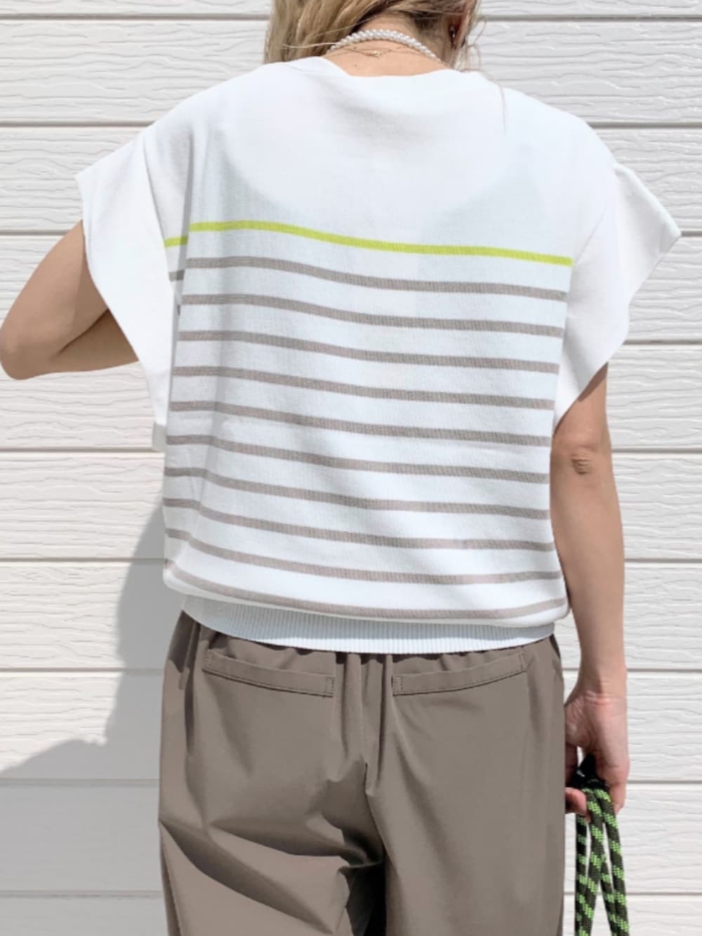 グレー系のその他パンツ、グレー系のトートバッグ、ホワイト系のニット/セーターを着用したレディースの春コーディネートの5枚目の写真