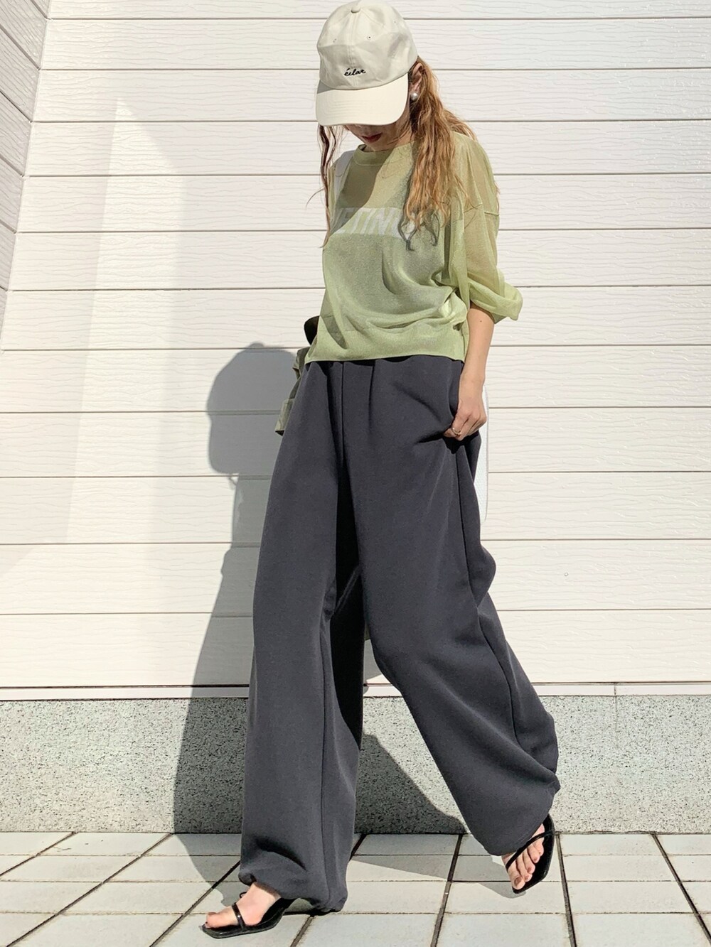 グリーン系のノーカラーコート、グリーン系のニット/セーター、ホワイト系のショルダーバッグを着用したレディースの春コーディネートの4枚目の写真