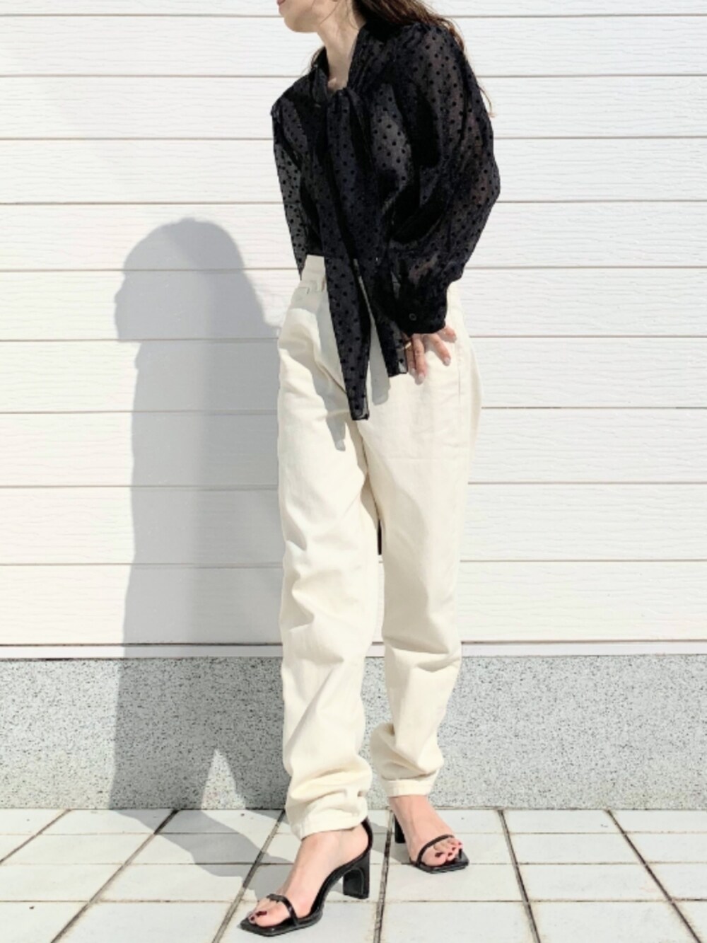 ブラック系のショルダーバッグ、ホワイト系のデニムパンツ、ブラック系のシャツ/ブラウスを着用したレディースの春コーディネートの2枚目の写真