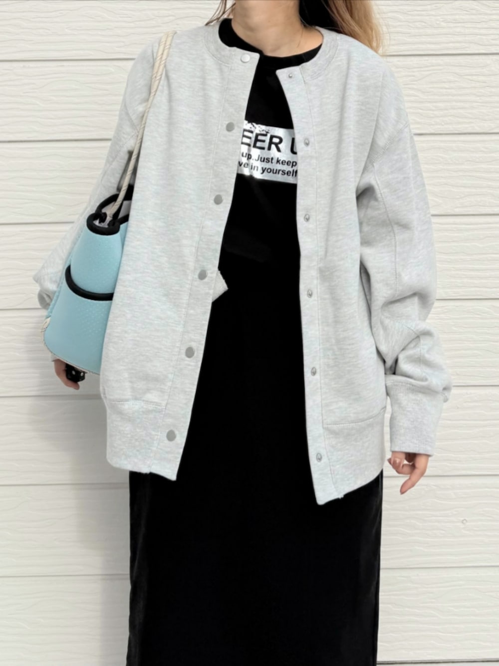 シルバー系のスニーカー、ブラック系のスカート、ブルー系のトートバッグを着用したレディースの秋コーディネートの3枚目の写真