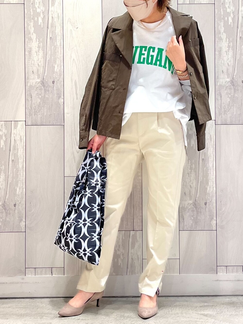 ブラック系のエコバッグ/サブバッグ、ホワイト系のTシャツ/カットソー、グリーン系のブルゾンを着用したレディースの夏コーディネートの2枚目の写真