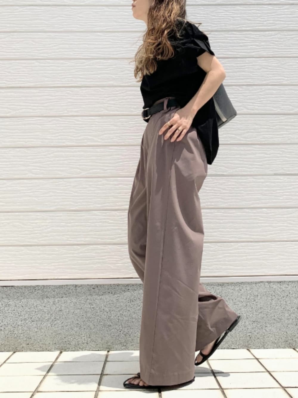 ブラウン系のその他パンツ、グレー系のトートバッグ、ブラック系のTシャツ/カットソーを着用したレディースの春コーディネートの3枚目の写真