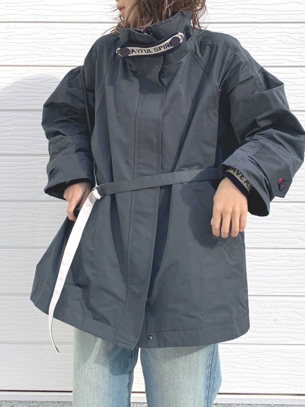 ブルー系のデニムパンツ、グレー系のその他アウター、ホワイト系のニット/セーターを着用したレディースの冬コーディネートの3枚目の写真