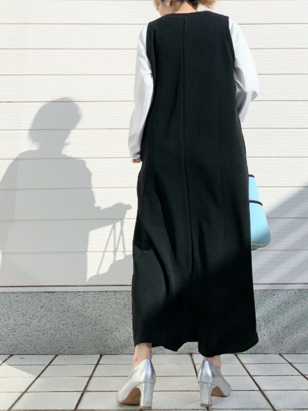 ブルー系のトートバッグ、ブラック系のワンピース、ホワイト系のTシャツ/カットソーを着用したレディースの冬コーディネートの3枚目の写真