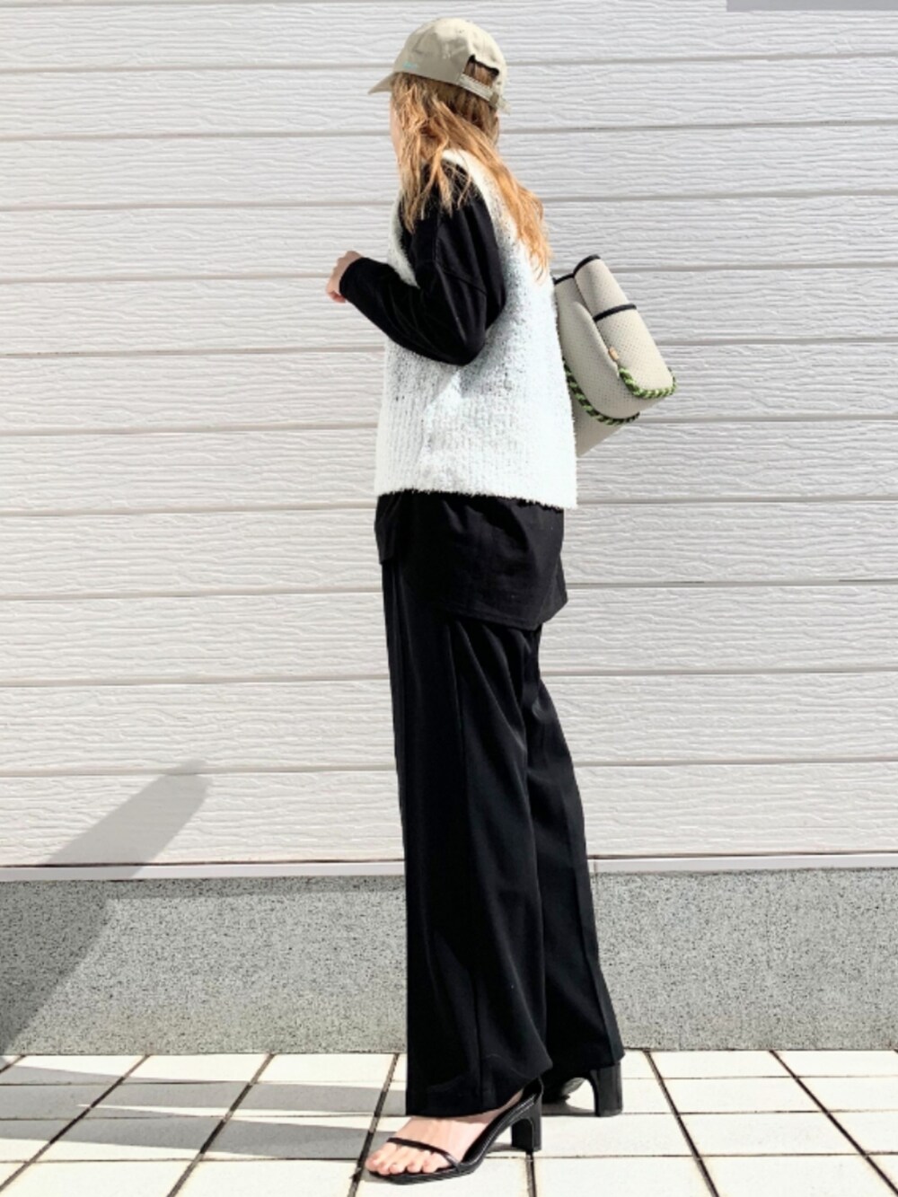 グレー系のトートバッグ、ブラック系のスラックス、ブラック系のTシャツ/カットソーを着用したレディースの冬コーディネートの2枚目の写真