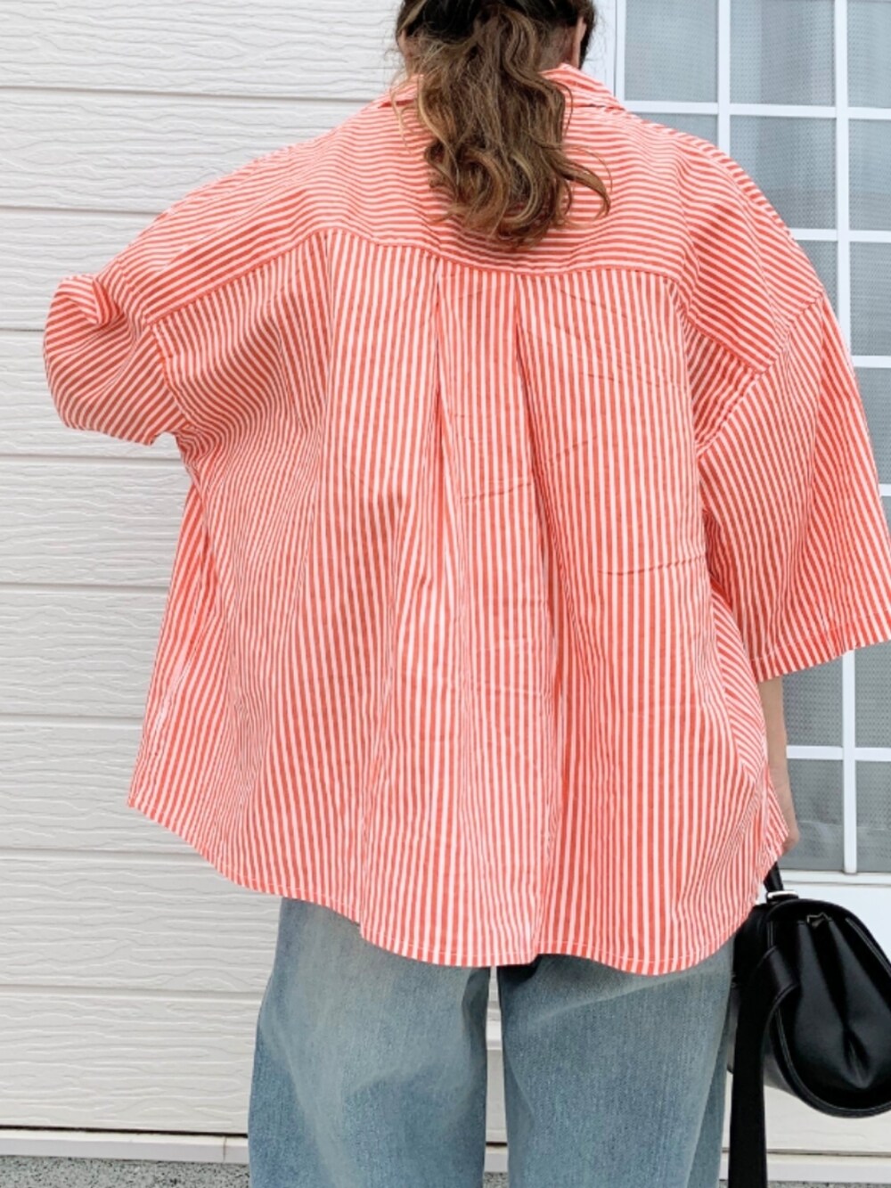 ブルー系のデニムパンツ、ベージュ系のタンクトップ、オレンジ系のシャツ/ブラウスを着用したレディースの夏コーディネートの4枚目の写真