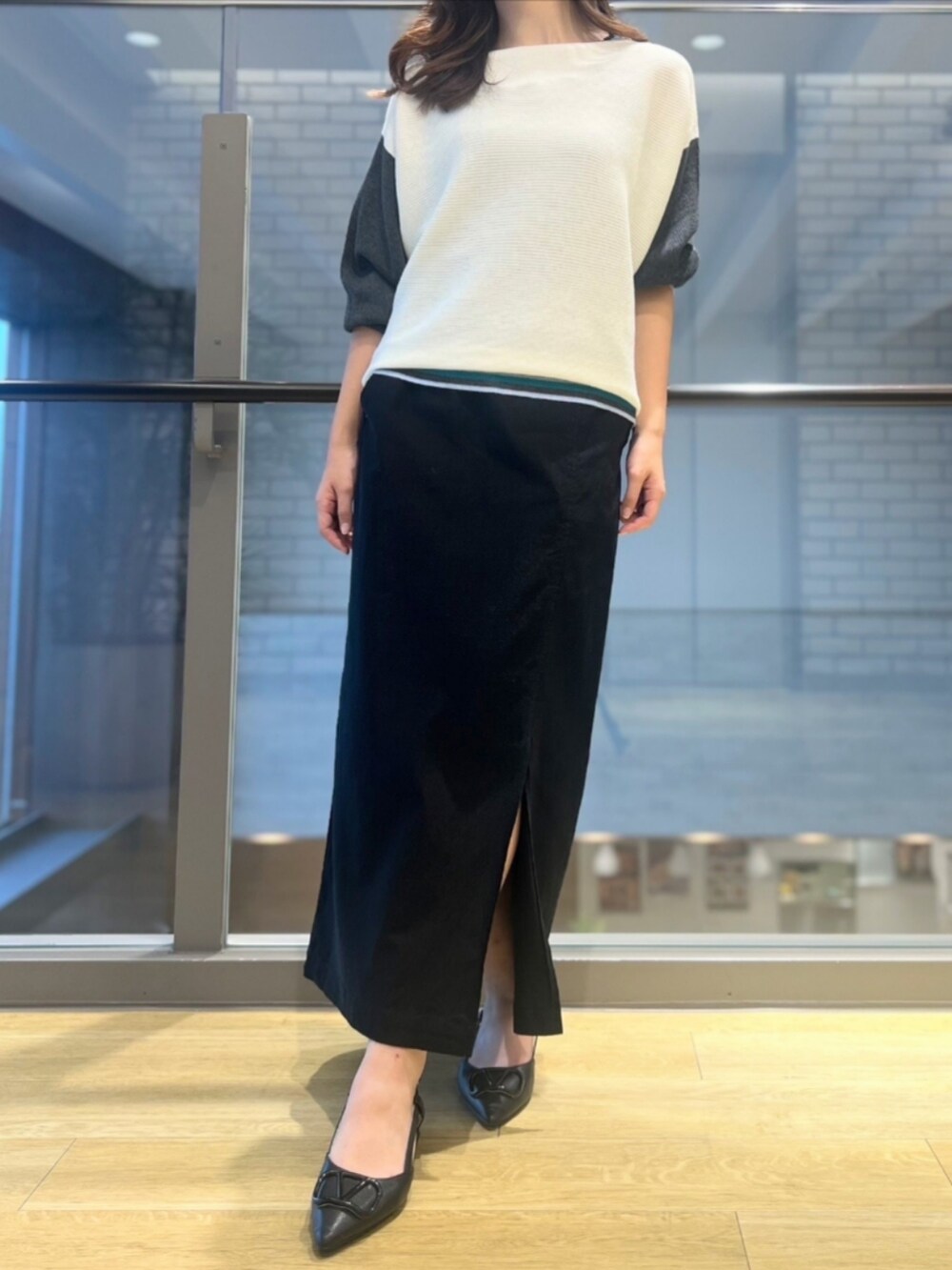 ホワイト系のニット/セーター、ブラック系のスカートを着用したレディースの秋コーディネートの2枚目の写真