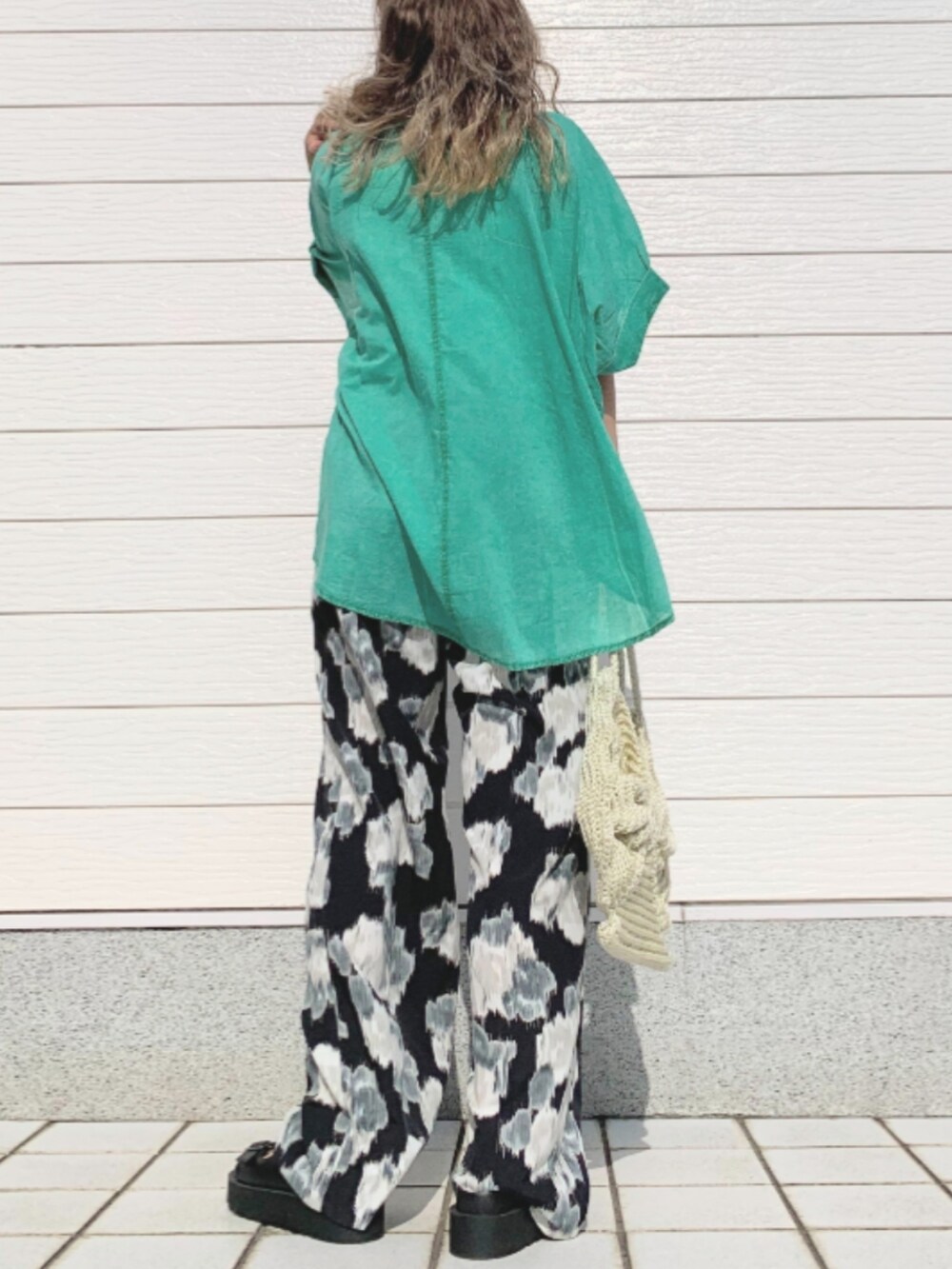 ホワイト系のトートバッグ、ブラック系のその他パンツ、ブラック系のサンダルを着用したレディースの春コーディネートの3枚目の写真