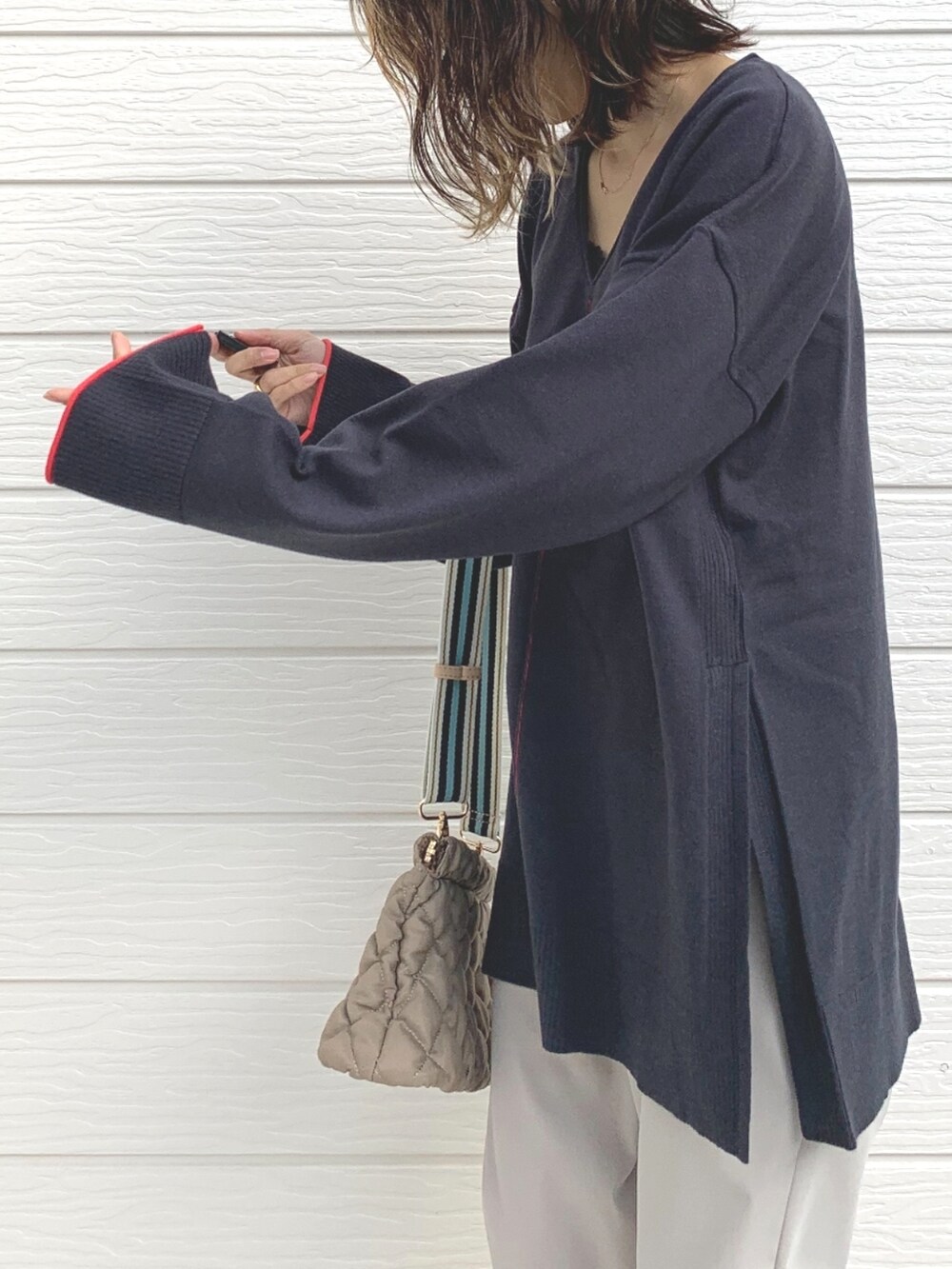 ホワイト系のその他パンツ、グレー系のニット/セーター、ベージュ系のショルダーバッグを着用したレディースの冬コーディネートの4枚目の写真