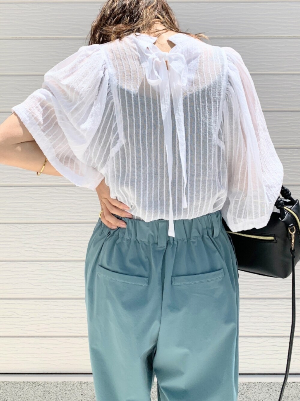 ホワイト系のシャツ/ブラウス、ブルー系のその他パンツ、ブラック系のハンドバッグを着用したレディースの春コーディネートの5枚目の写真