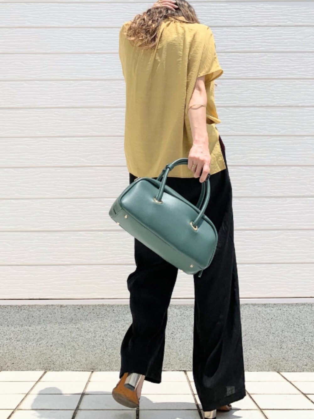 ブラック系のその他パンツ、ブラウン系のサンダル、イエロー系のシャツ/ブラウスを着用したレディースの夏コーディネートの3枚目の写真