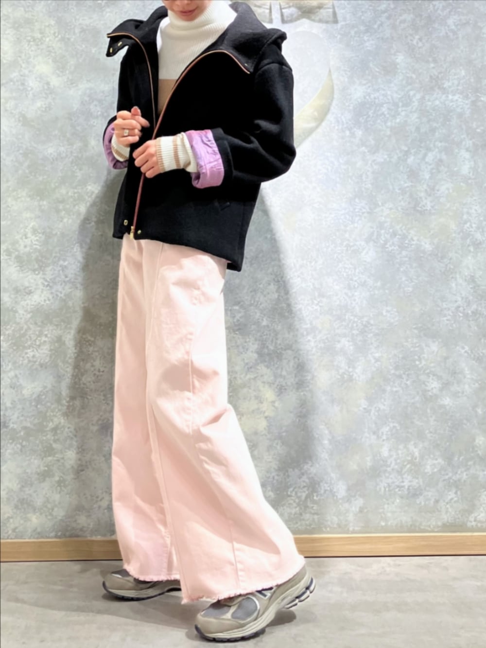 ブラック系のトートバッグ、ピンク系のデニムパンツ、ホワイト系のニット/セーターを着用したレディースの冬コーディネートの3枚目の写真