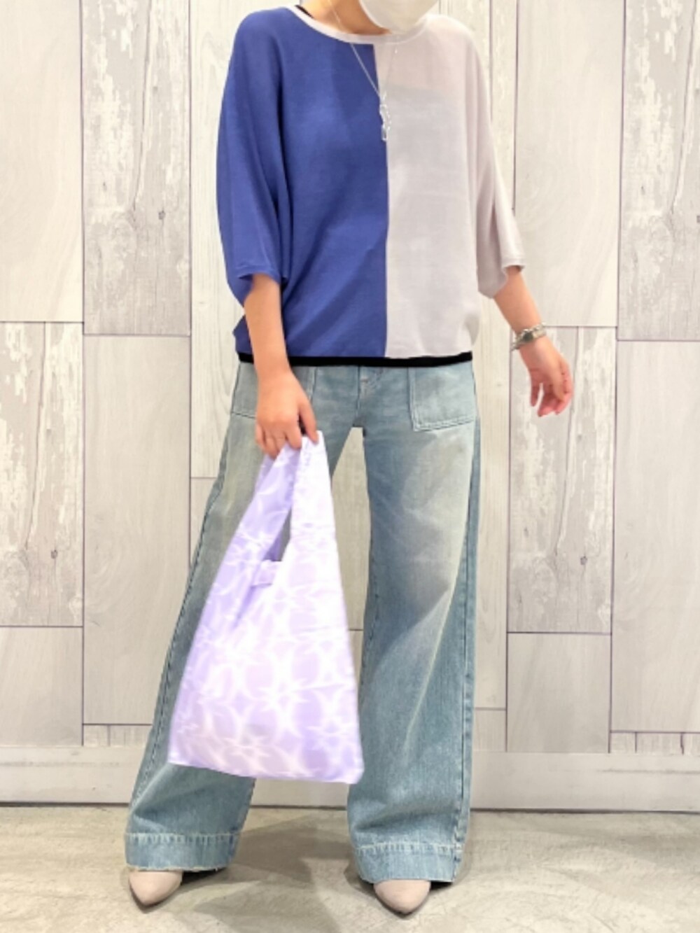 ブルー系のデニムパンツ、グレー系のニット/セーター、パープル系のエコバッグ/サブバッグを着用したレディースの春コーディネートの2枚目の写真